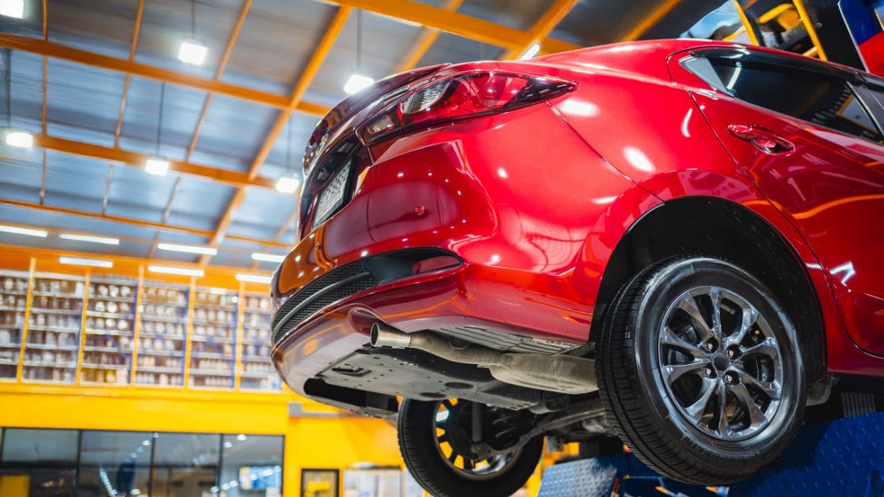 Veículo no elevador automotivo durante manutenção básica em oficina mecânica.